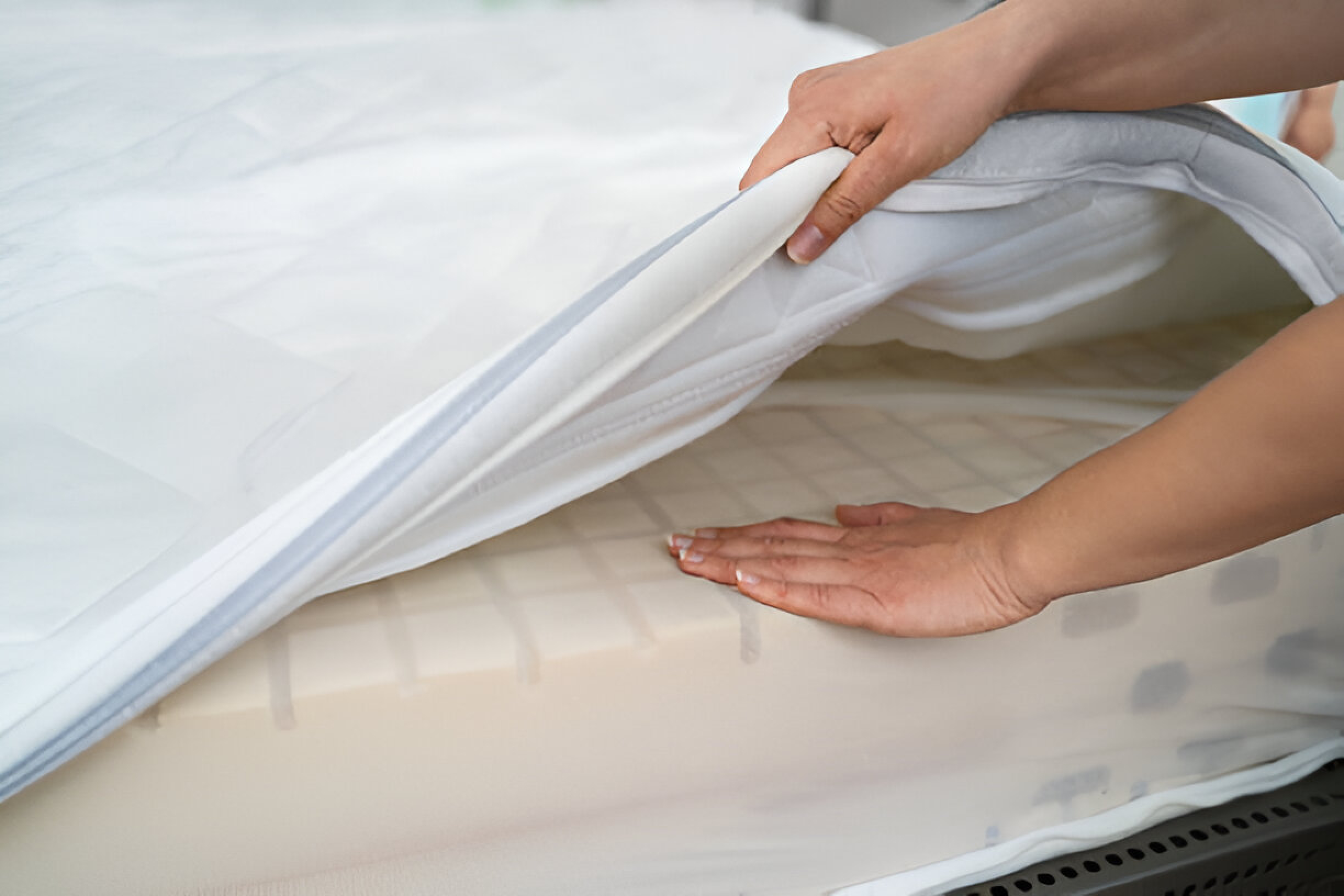 "Protector being placed on a white mattress to help prolong the life of your mattress.