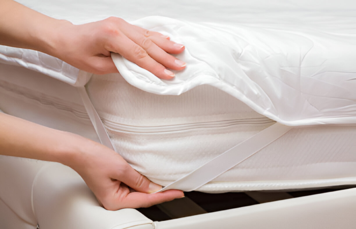 "Protector being placed on a white mattress to help prolong the life of your mattress.