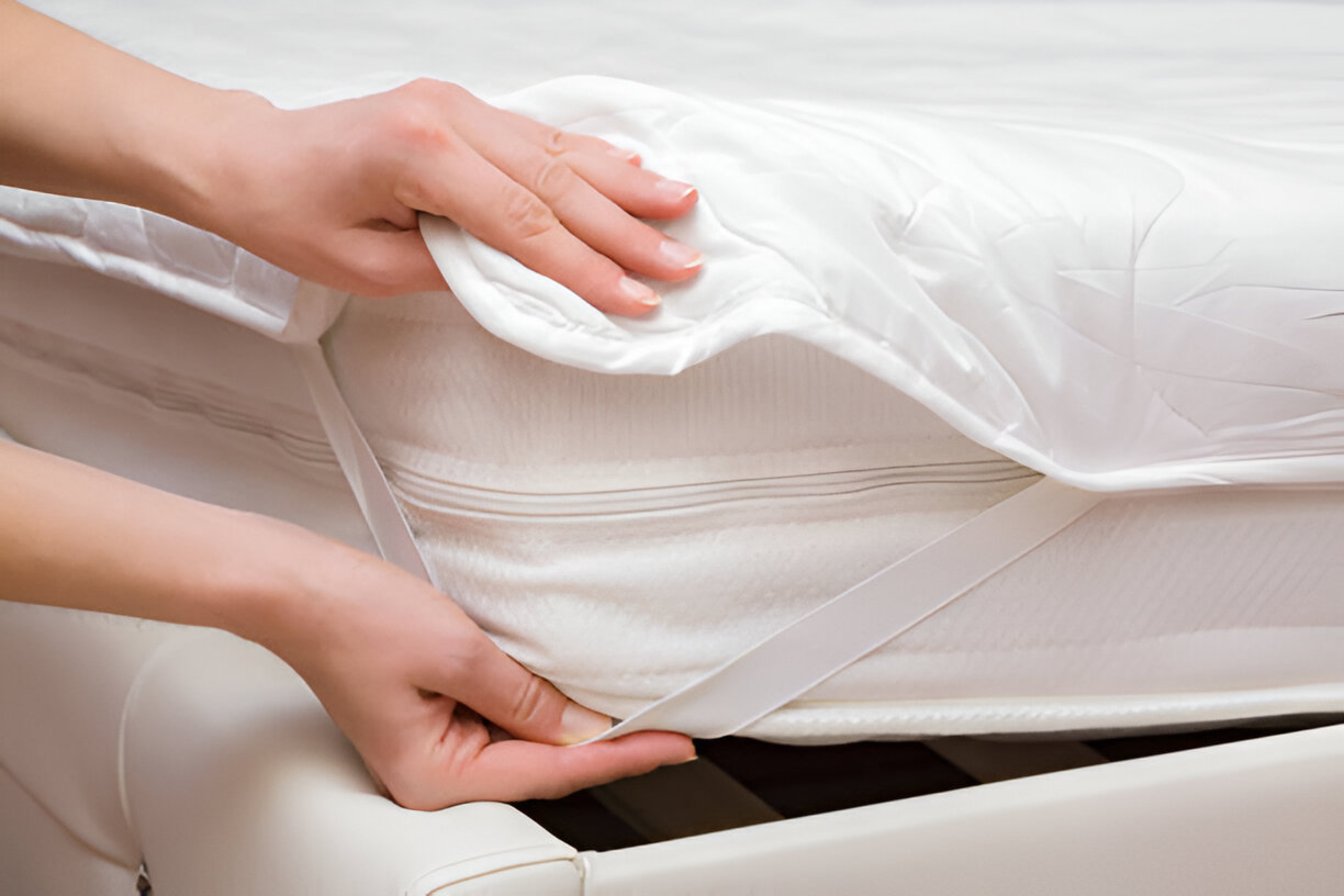 "Protector being placed on a white mattress to help prolong the life of your mattress.